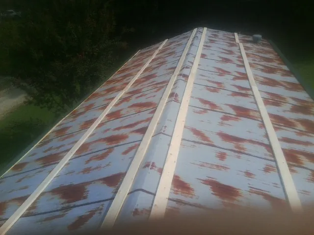 Rusted metal roof panels with new wood purlins before replacement — Storm Damage Roof Repair in Great Neck by Roofing Brothers