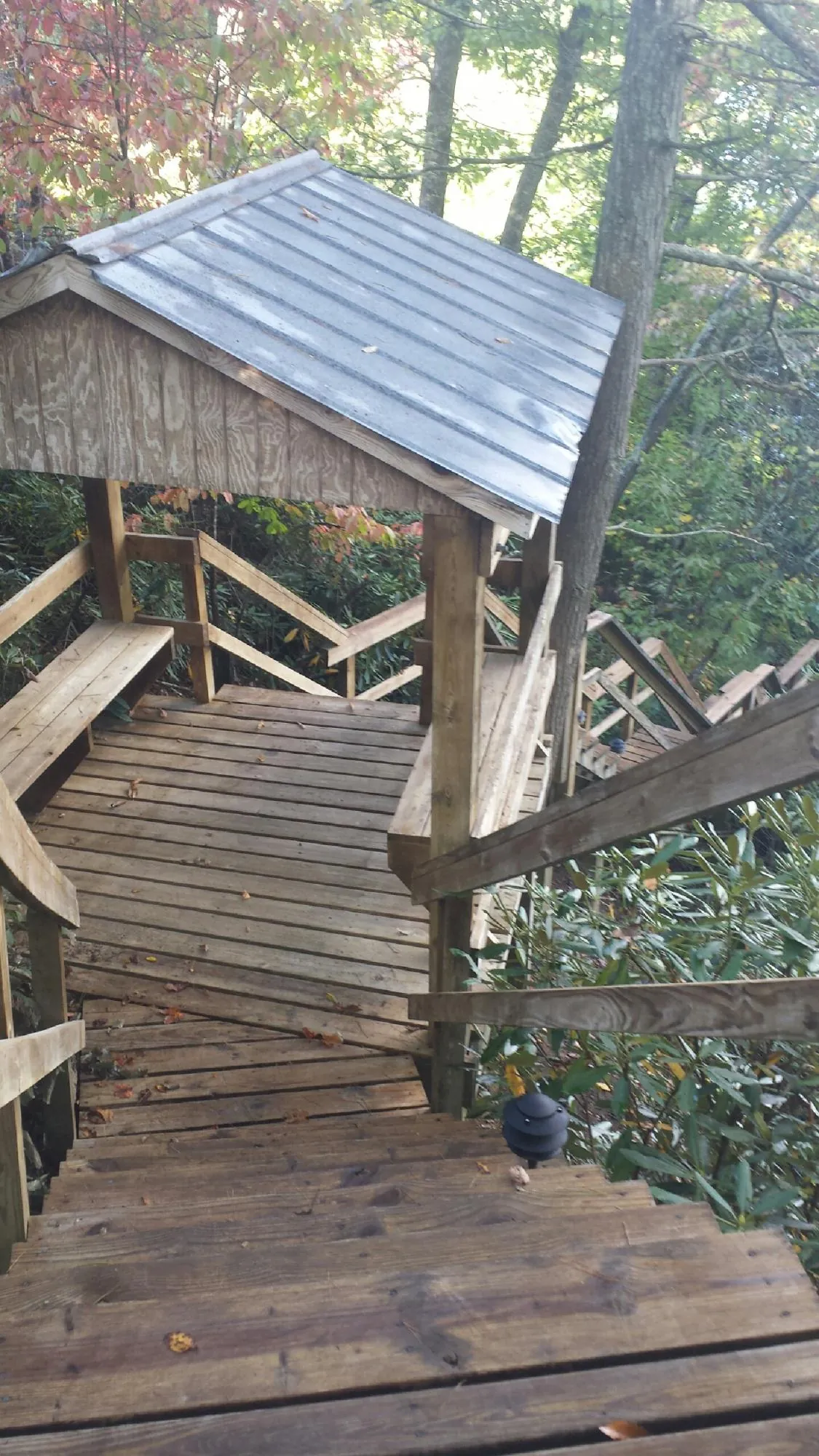 Metal roofed shelter over wooden steps on a wooded walkway — Skylight Repair & Installation work by our crew in Great Neck