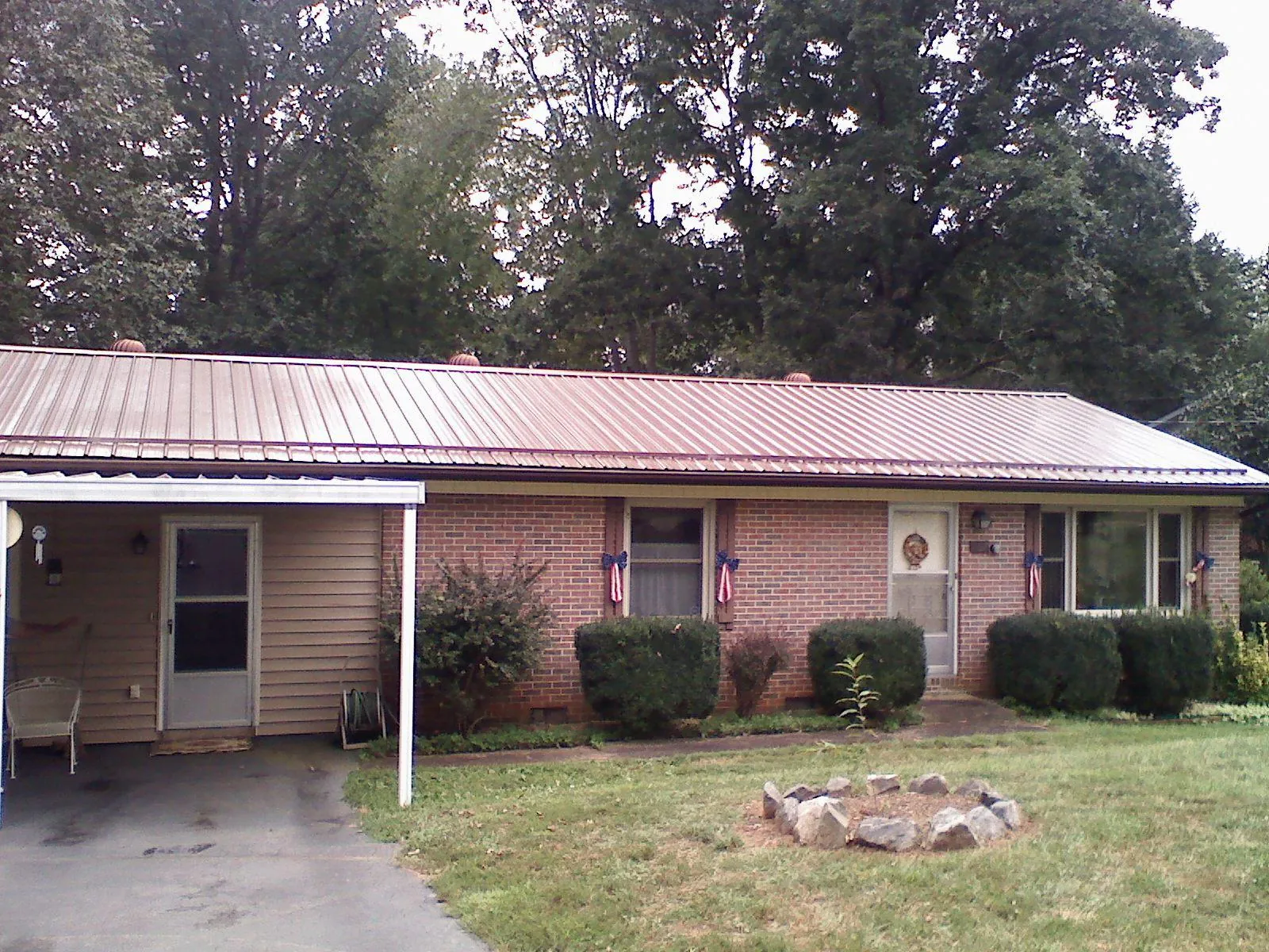 Bronze metal roof and carport on a brick ranch home — Roof Repair work by our crew in Great Neck